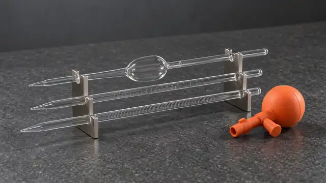 Pipetas volumétrica e graduadas de vidro num suporte, com uma pera de borracha, sobre a bancada